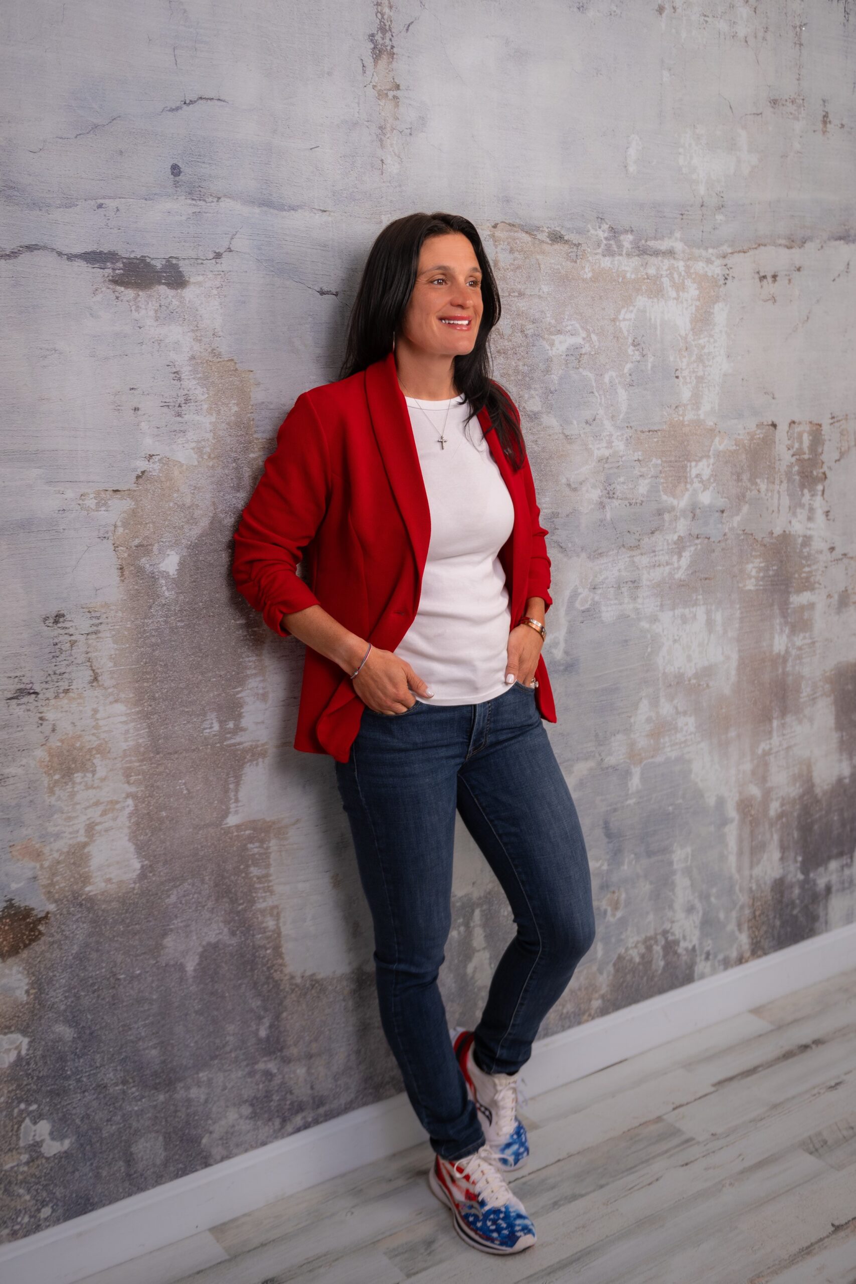 jenn caputi posing on a wall in professional photoshoot